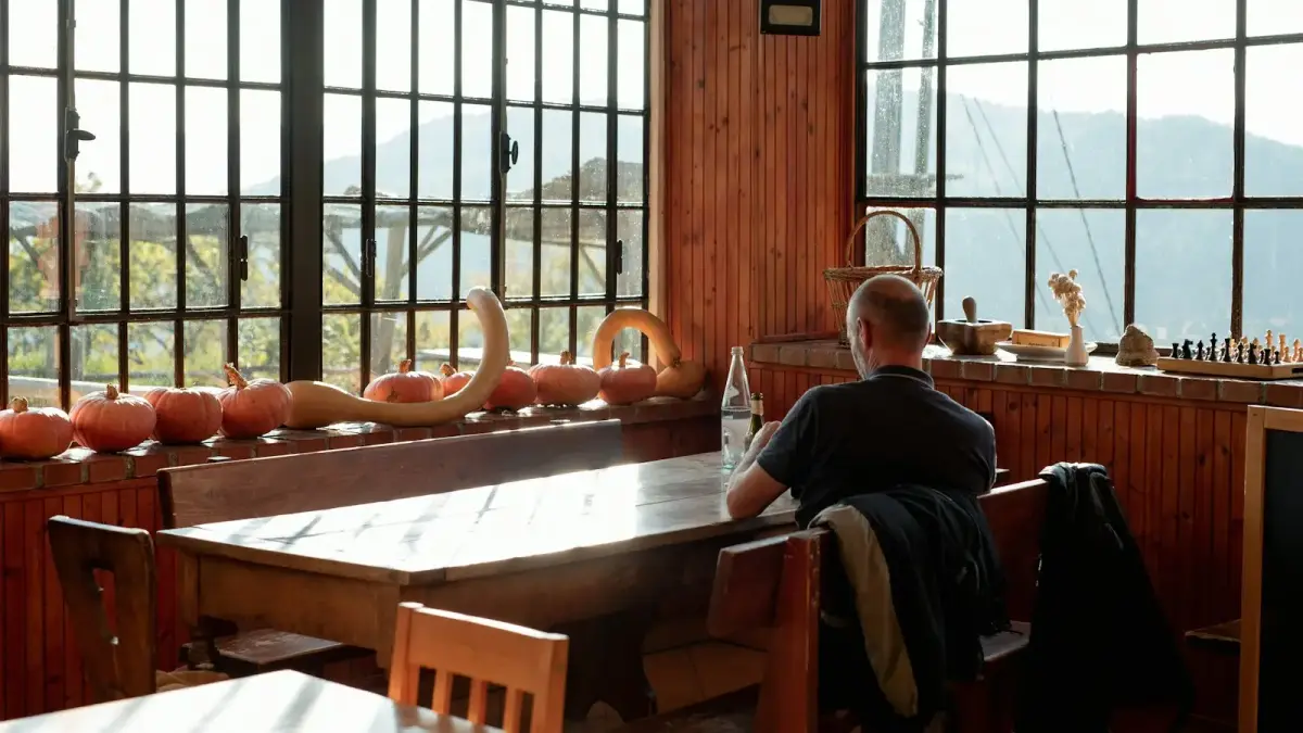 a man sitting at a table looking out a window