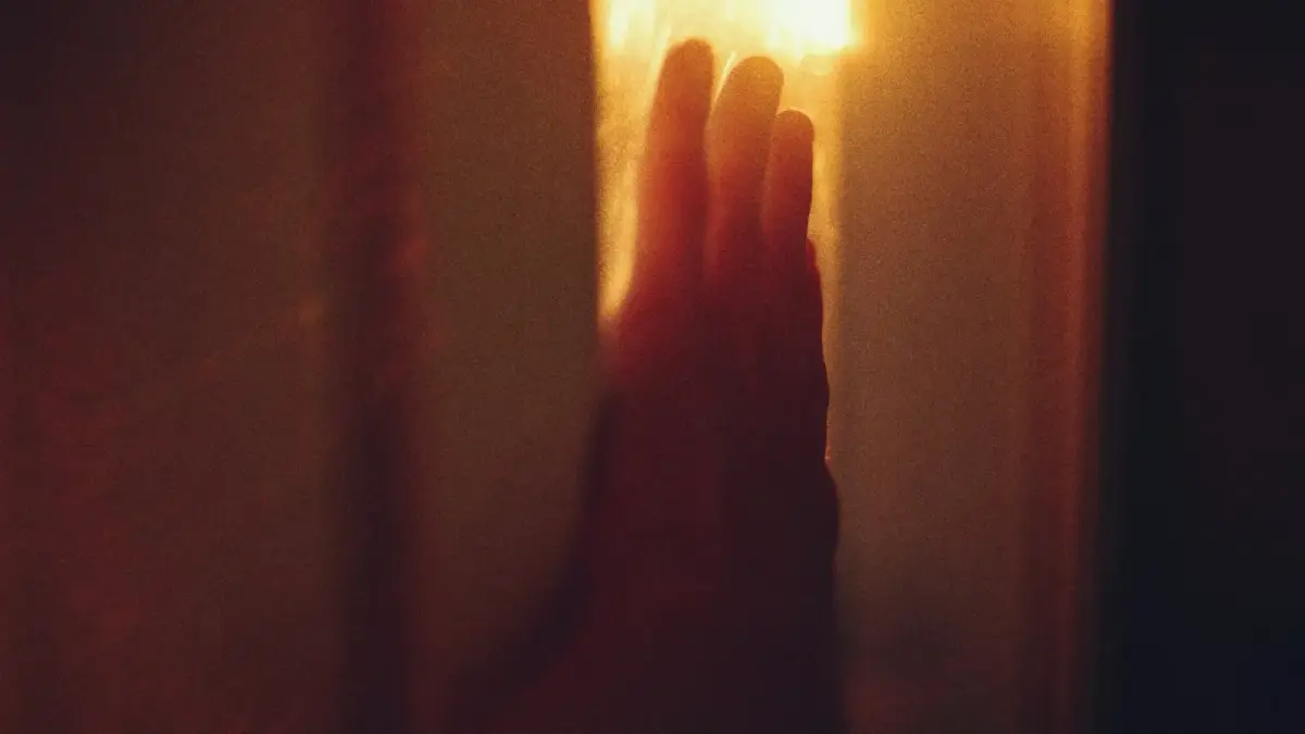 A hand reaching towards a bright light source
