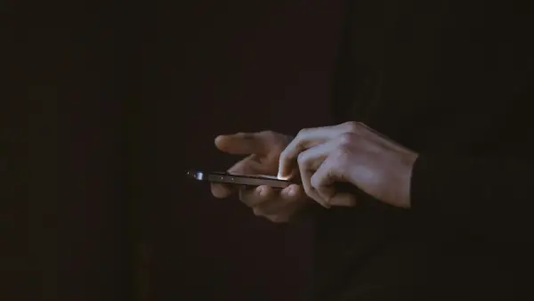 silhouette photo of person holding smartphone
