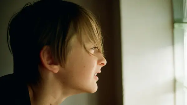 A woman looking out a window at the outside
