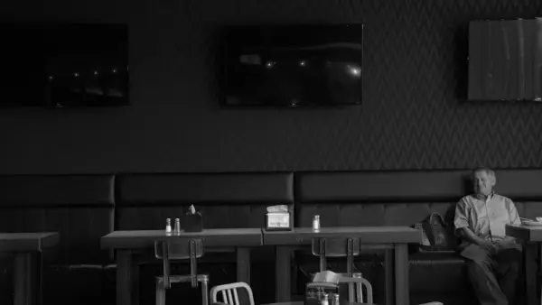 Man sitting alone in a dimly lit diner booth