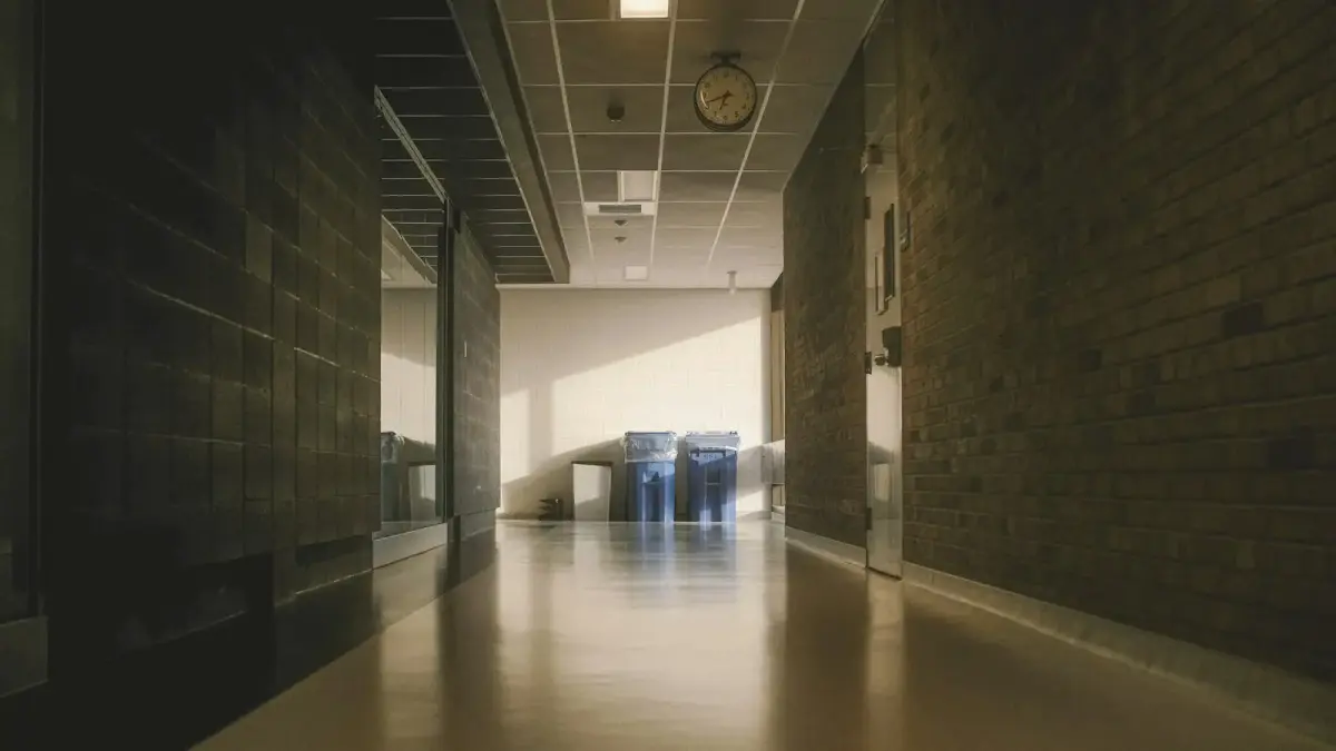A long hallway with brick walls and bright lighting.