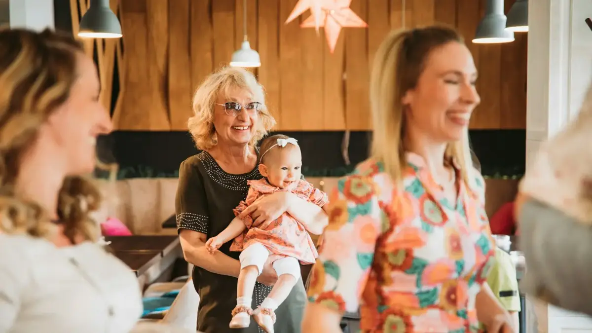 a group of women standing around each other holding a baby