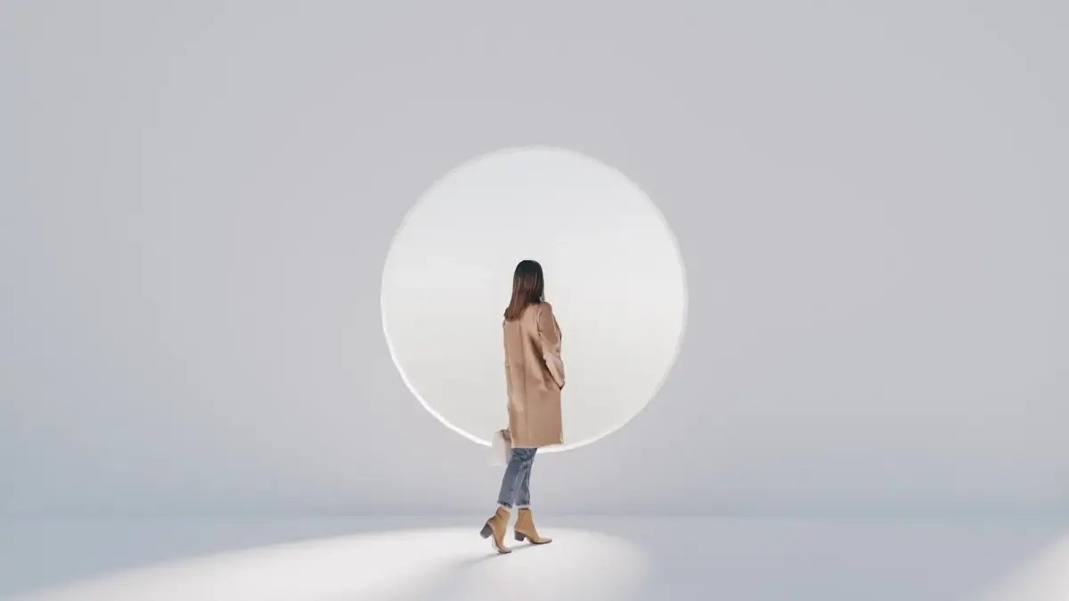 a woman standing in front of a round mirror