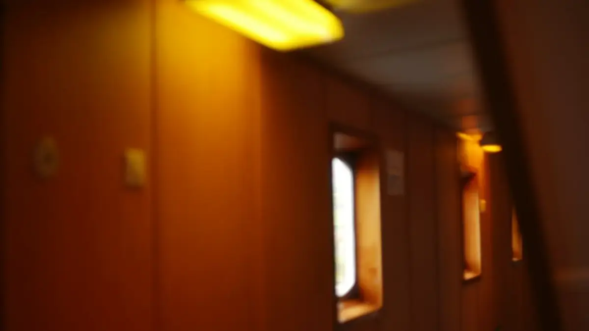 Orange-walled corridor with bright windows and yellow ceiling light