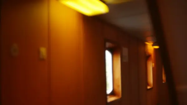 Orange-walled corridor with bright windows and yellow ceiling light