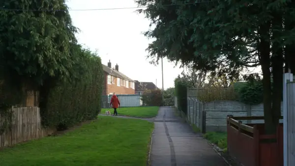 A person in a red coat walks on a path