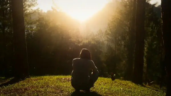 A quiet person sitting alone in soft light, contemplative