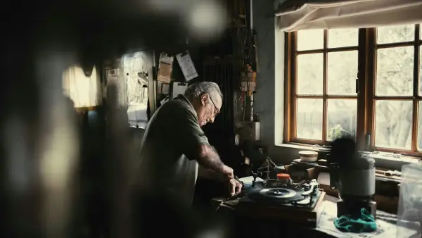 A father looking out a window in warm evening light