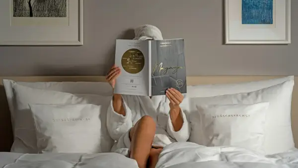 a person reading a book on a bed