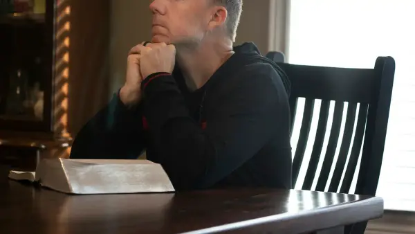 A person sitting quietly after a crisis, soft natural light