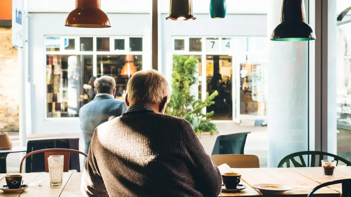 man in chair with table beside coffee