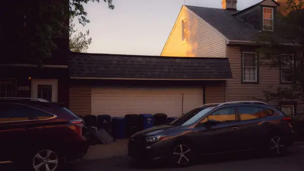 Residential street with parked cars and houses at sunset
