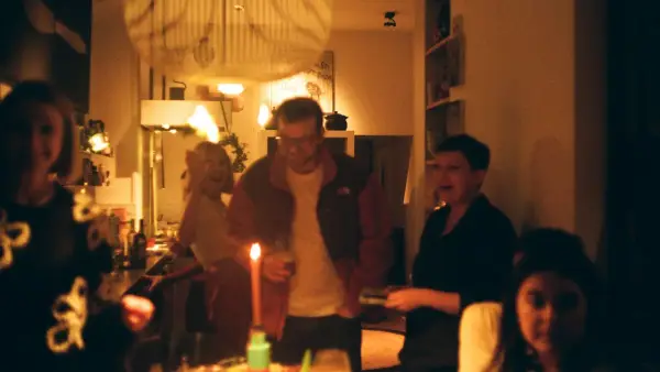 People gathered around a table with a lit candle