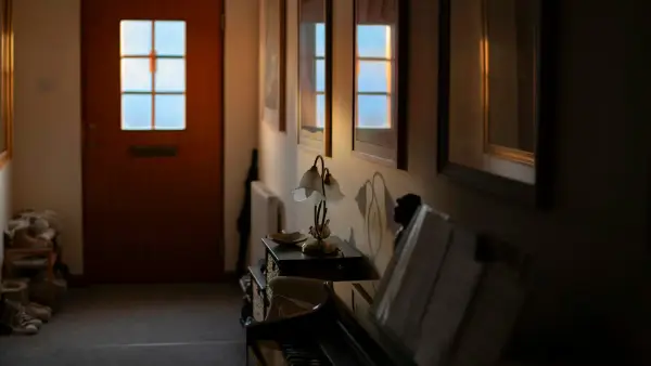 Hallway with a door, piano, and artwork