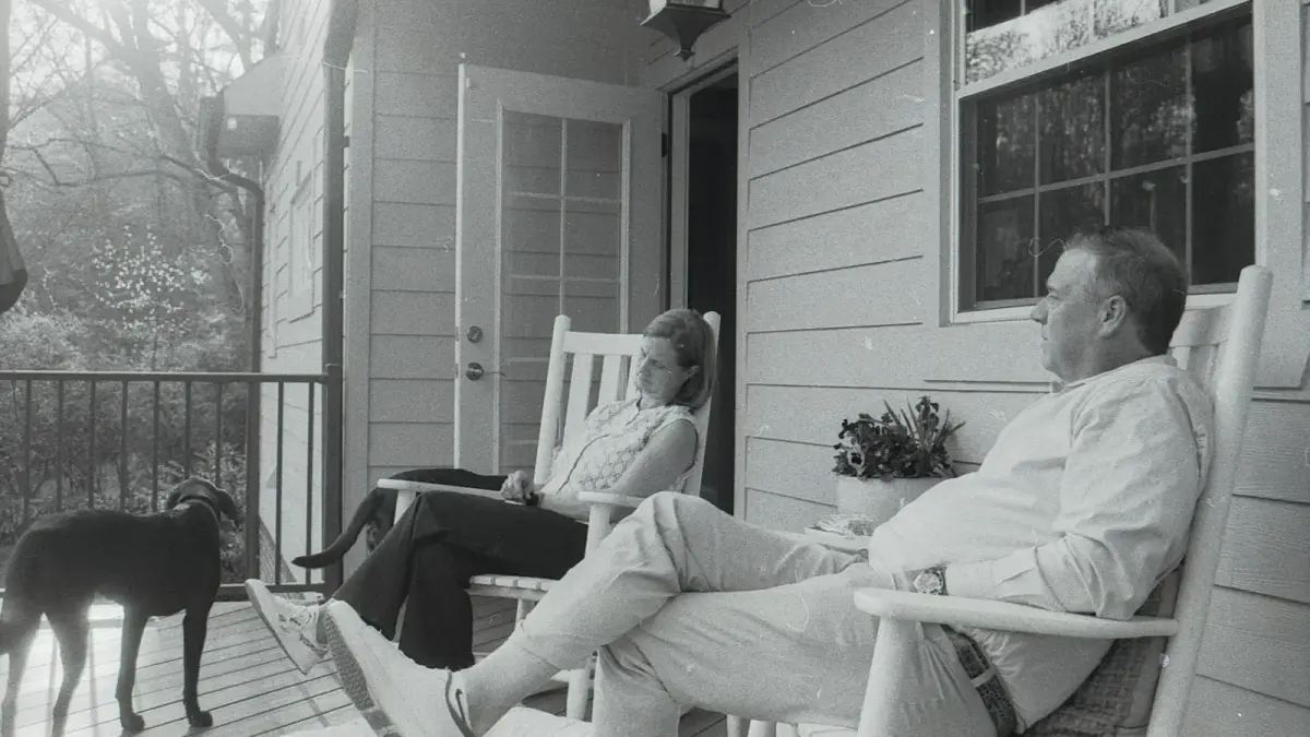A couple and their dog relaxing on a porch