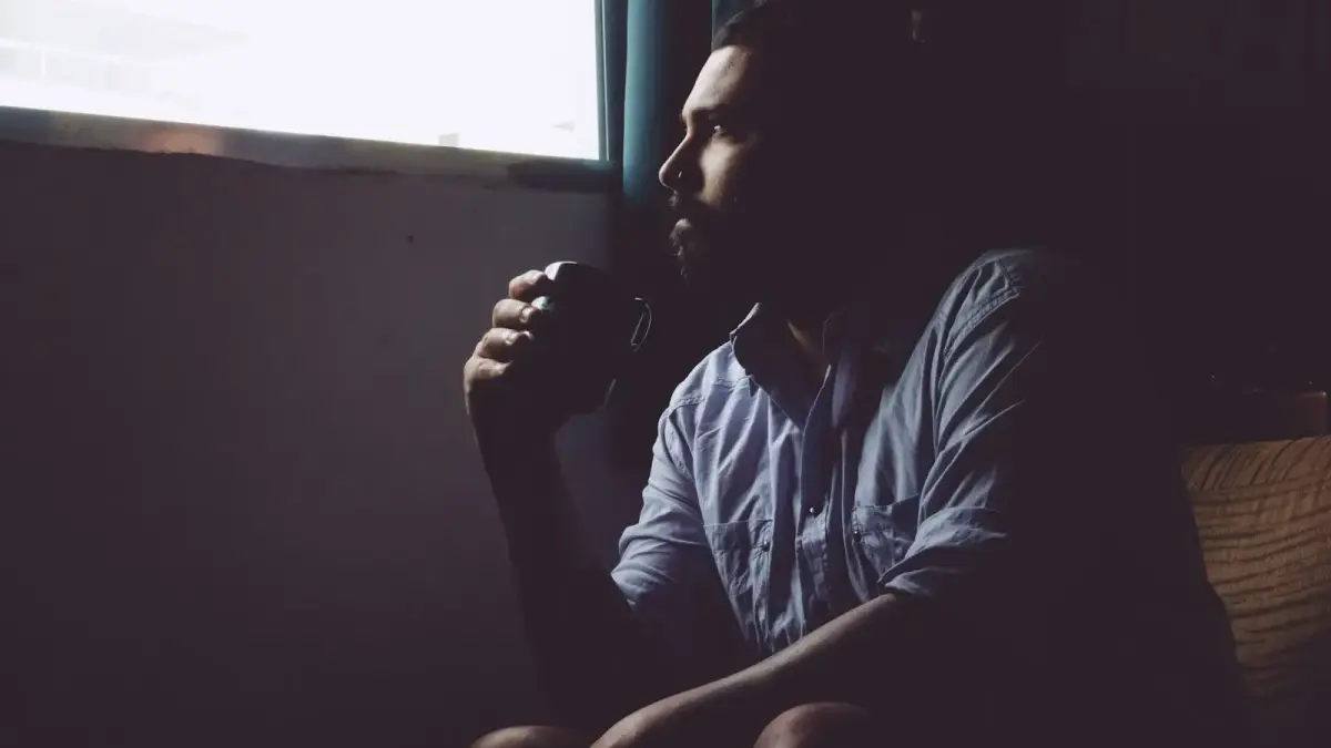 man sitting on chair holding mug