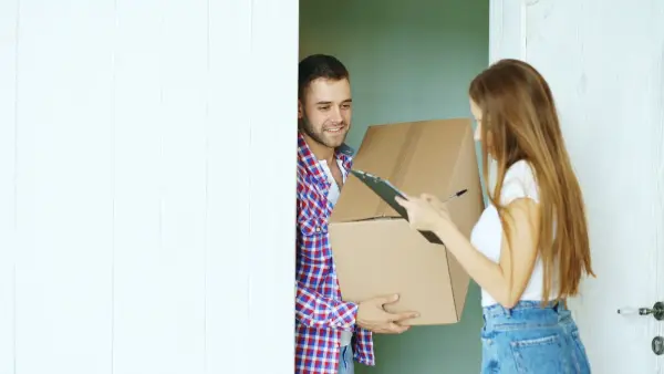 Couple signing for a package delivery at the door