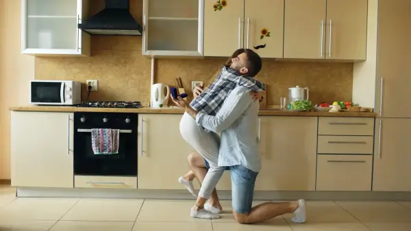 Couple embracing in a modern kitchen.
