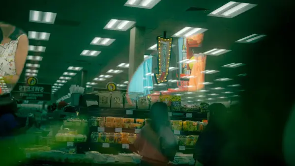 A quiet grocery store aisle in the evening, fluorescent lights casting a calm glow over empty shelves.