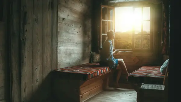 Older person sitting peacefully in quiet morning light