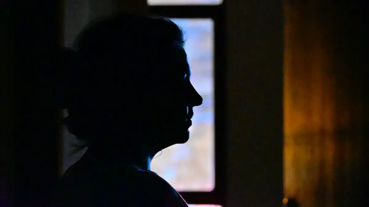 A person's silhouette stands in the dark