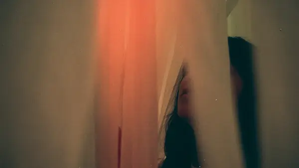 Blurred figure in a dimly lit hallway