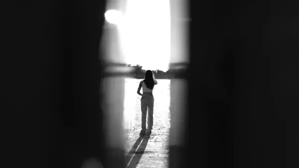 A person standing in a room with a light coming through the window