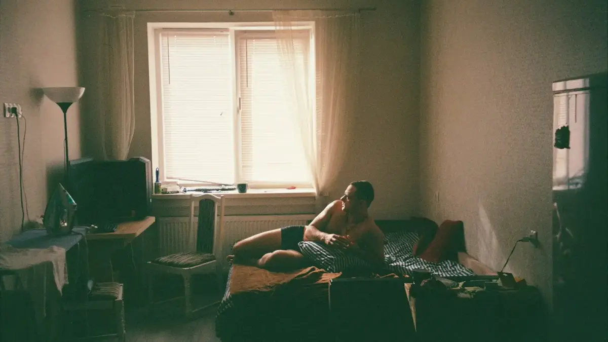 man in black shorts sitting on brown couch