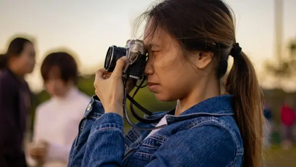 selective focus photography of woman holding black camera