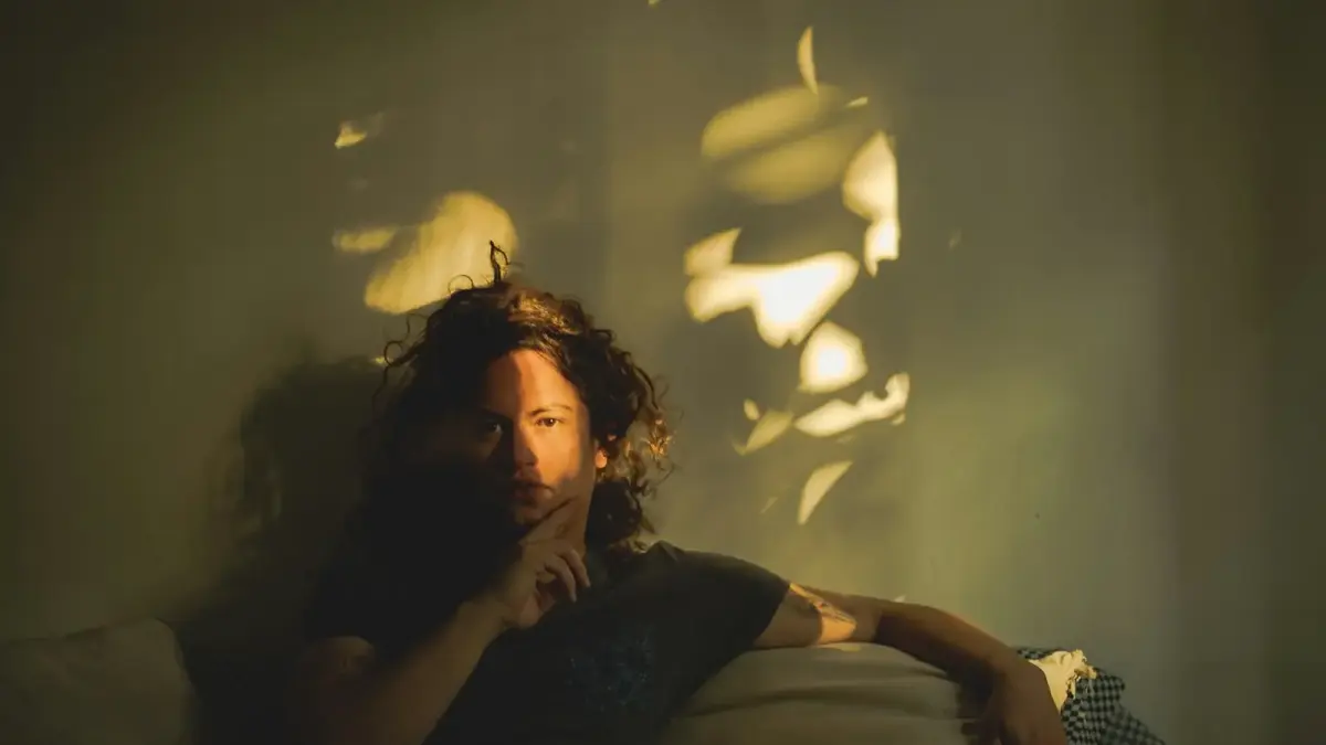 A man sitting on a couch in a dimly lit room