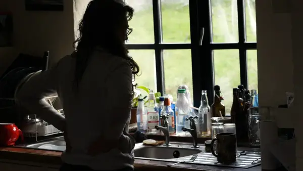 a woman standing in a kitchen next to a sink
