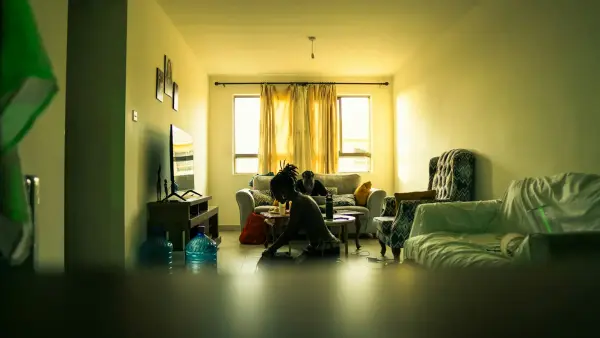 a woman standing in a doorway in soft light looking away contemplatively