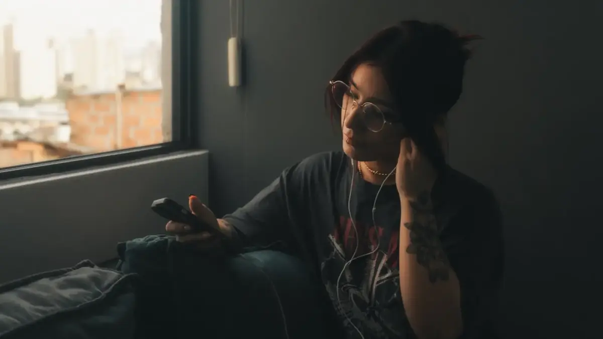 A woman sitting on a couch holding a cell phone to her ear