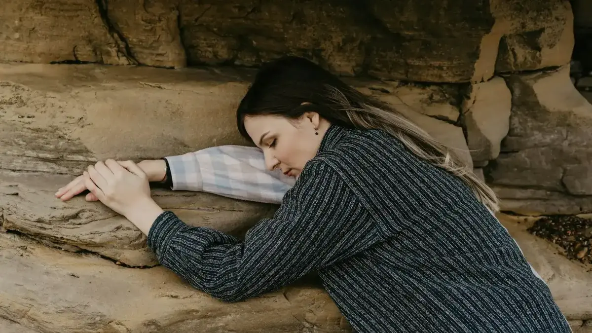 woman in black and white striped long sleeve shirt lying on brown sand
